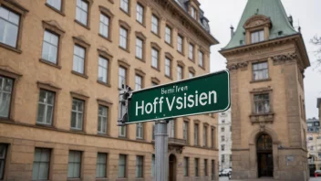 En gatestolpe med navnet Hoffsveien, med en historisk bygning i bakgrunnen.