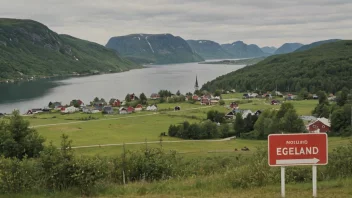 Et idyllisk norsk landskap med en liten landsby eller by i bakgrunnen, og et skilt eller et hus med navnet 'Egeland' i forgrunnen.